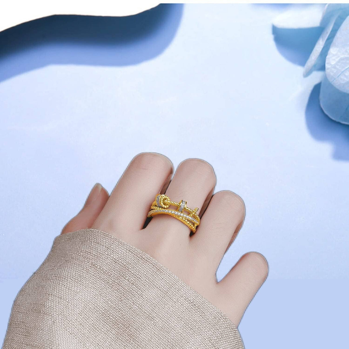 Gold-tone fidget ring with clear stone bands on an open hand