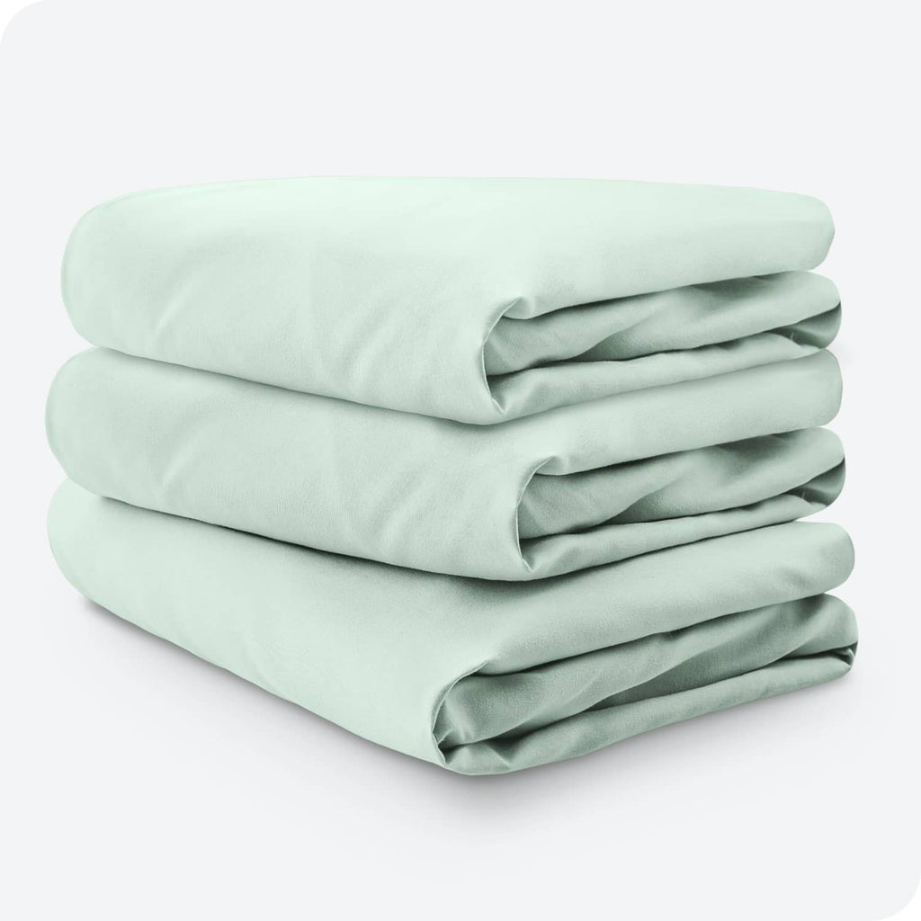 Three-pack mint green microfiber crib fitted sheets, neatly stacked