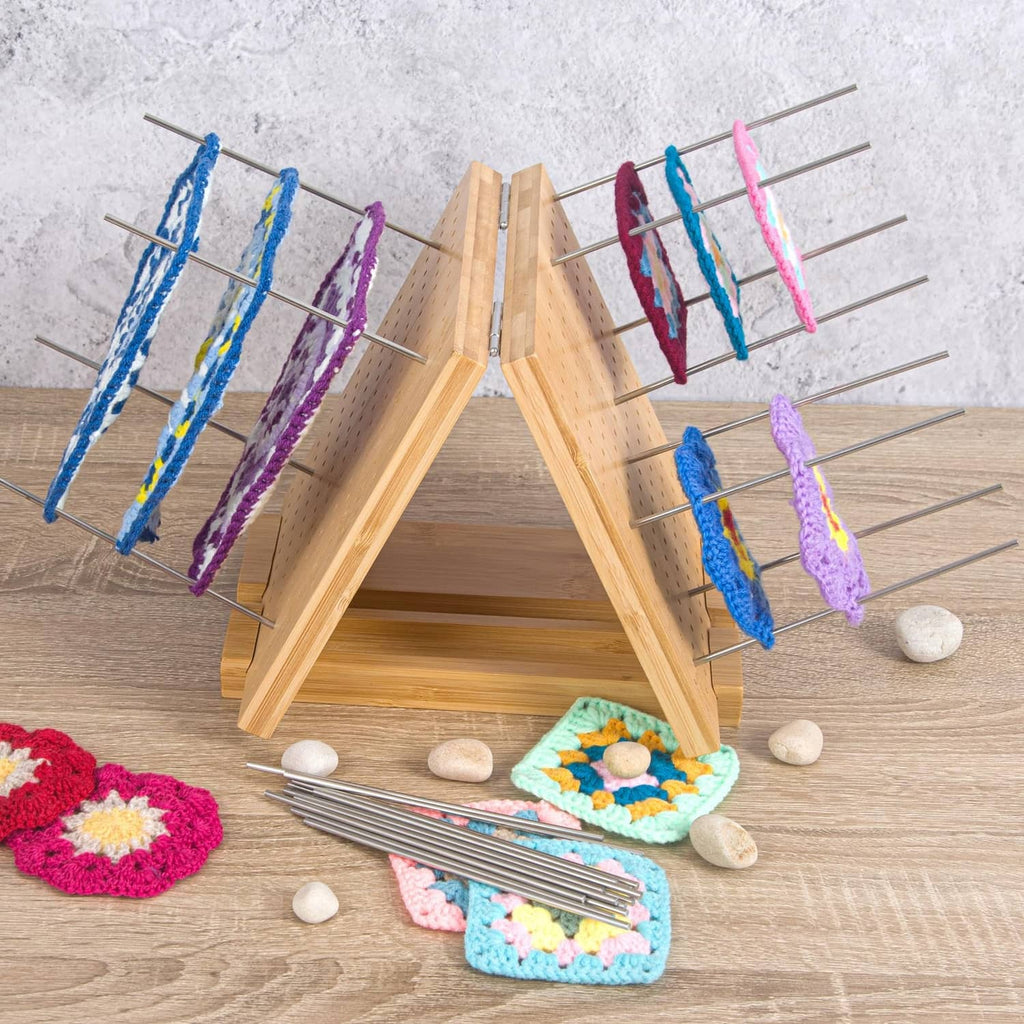 Crochet blocking board with base and peg pins holding small crochet pieces