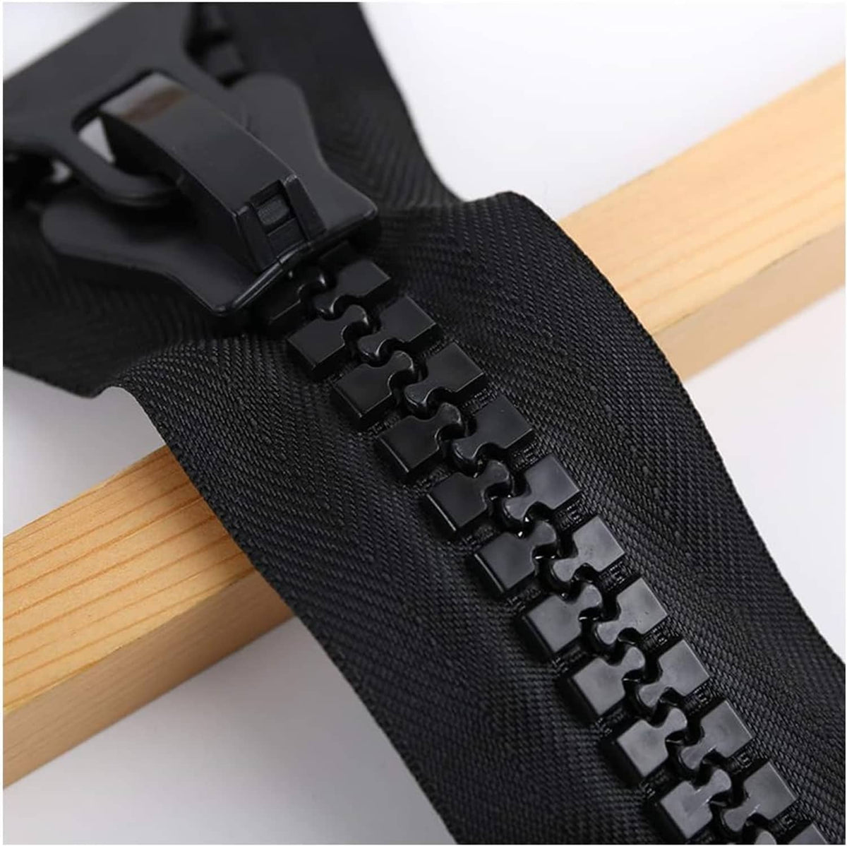 Black plastic zipper with chunky teeth and large pull on woven tape.