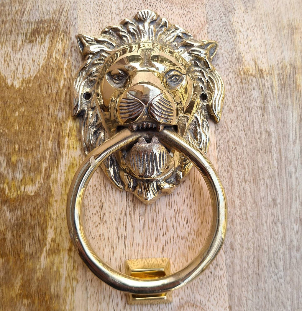 Brass lion door knocker with circular ring and detailed lion-face with arched mane