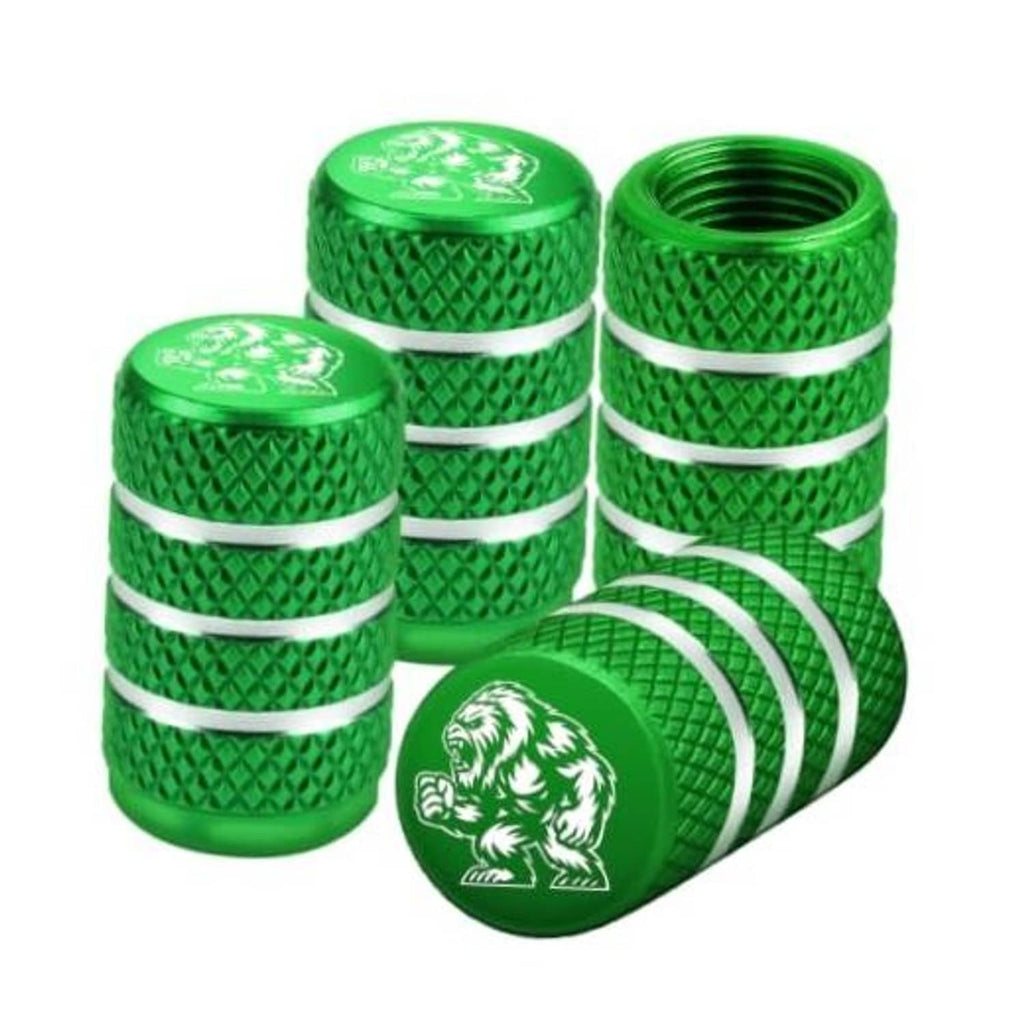 Set of four green Yeti tire valve stem caps with silver bands and embossed bear logo.