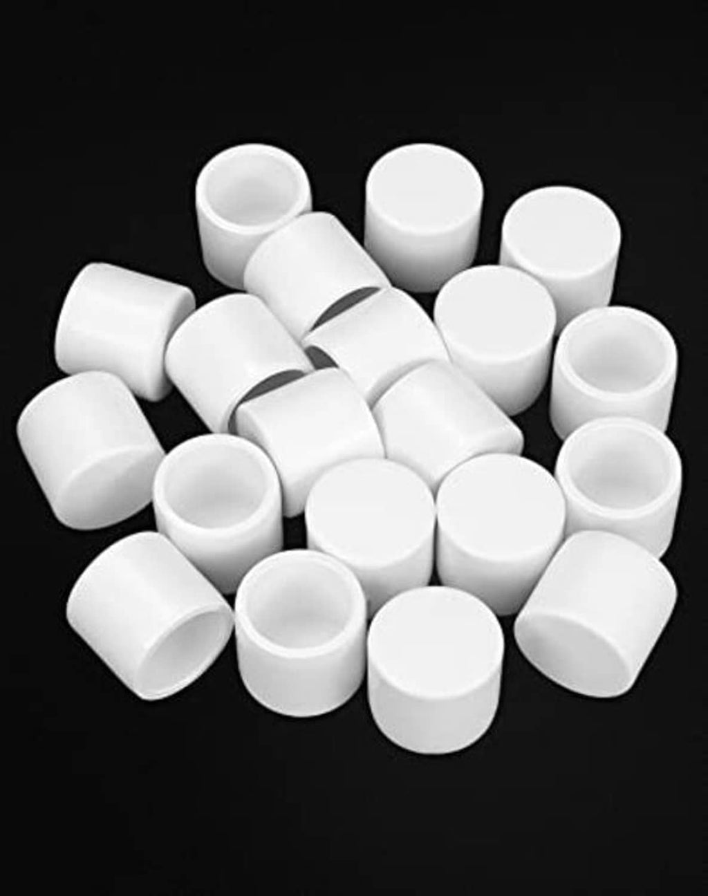 White PVC pipe end caps, small cylindrical plugs with hollow ends