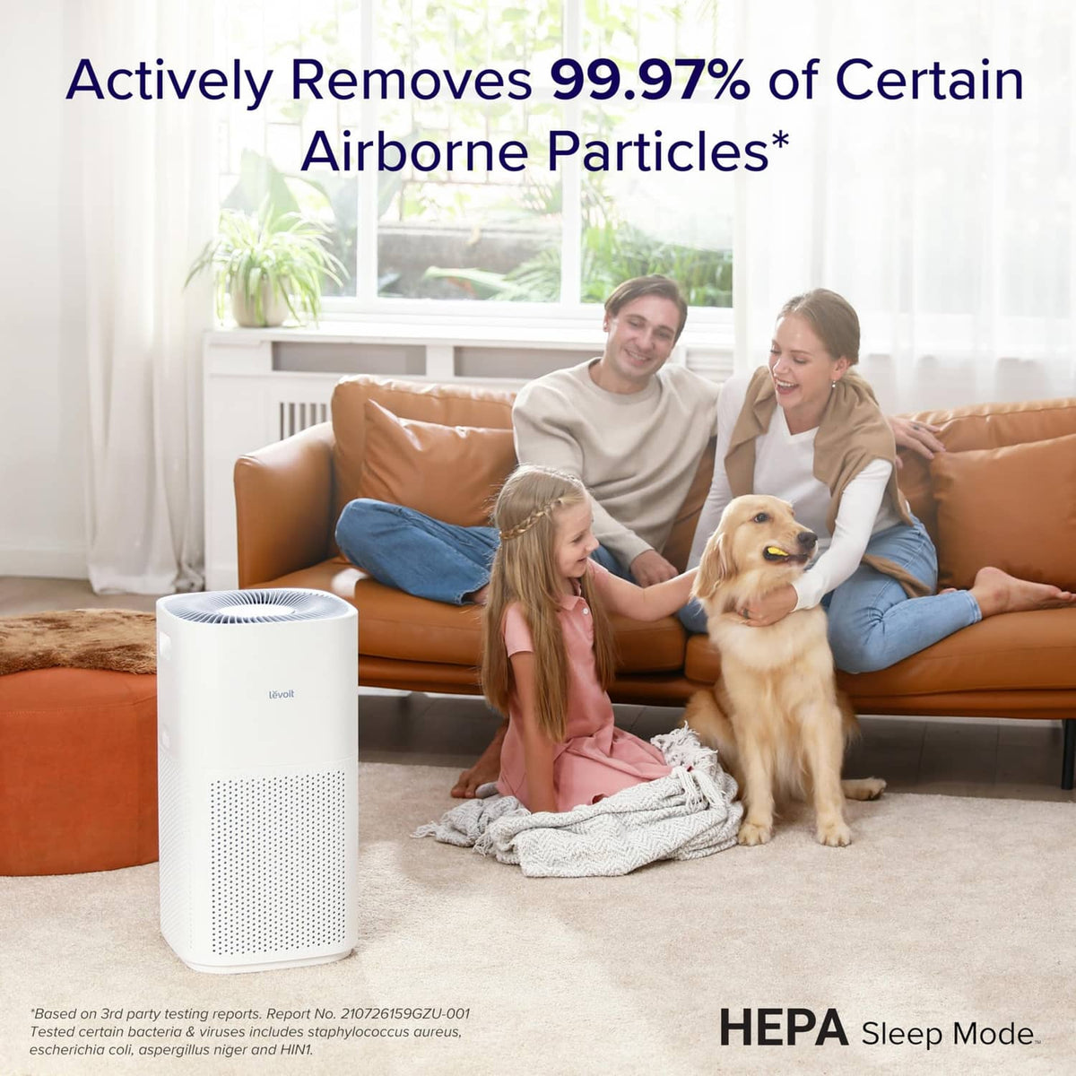 White Levoit air purifier near sofa, with top vent grille and front perforated panel