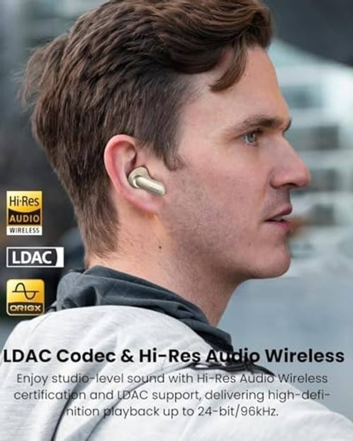 Titanium gold wireless earbuds worn in an ear