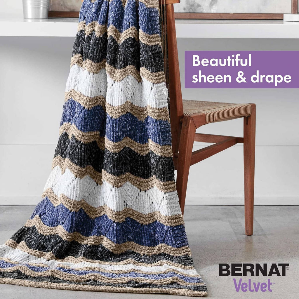 Chunky striped crochet blanket with blue, cream, and dark gray bands