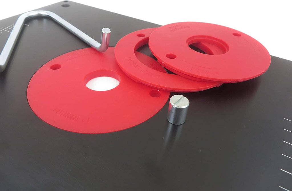 Black router table insert plate close-up with red circular ring inserts and threaded studs.