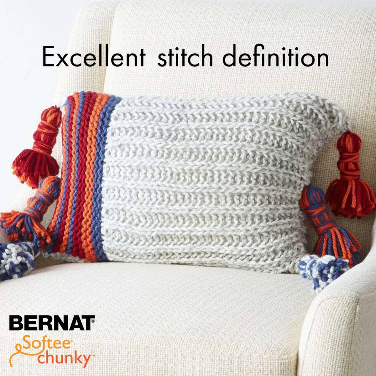 Chunky knit pillow cover with white cable texture and multicolor striped edge tassels