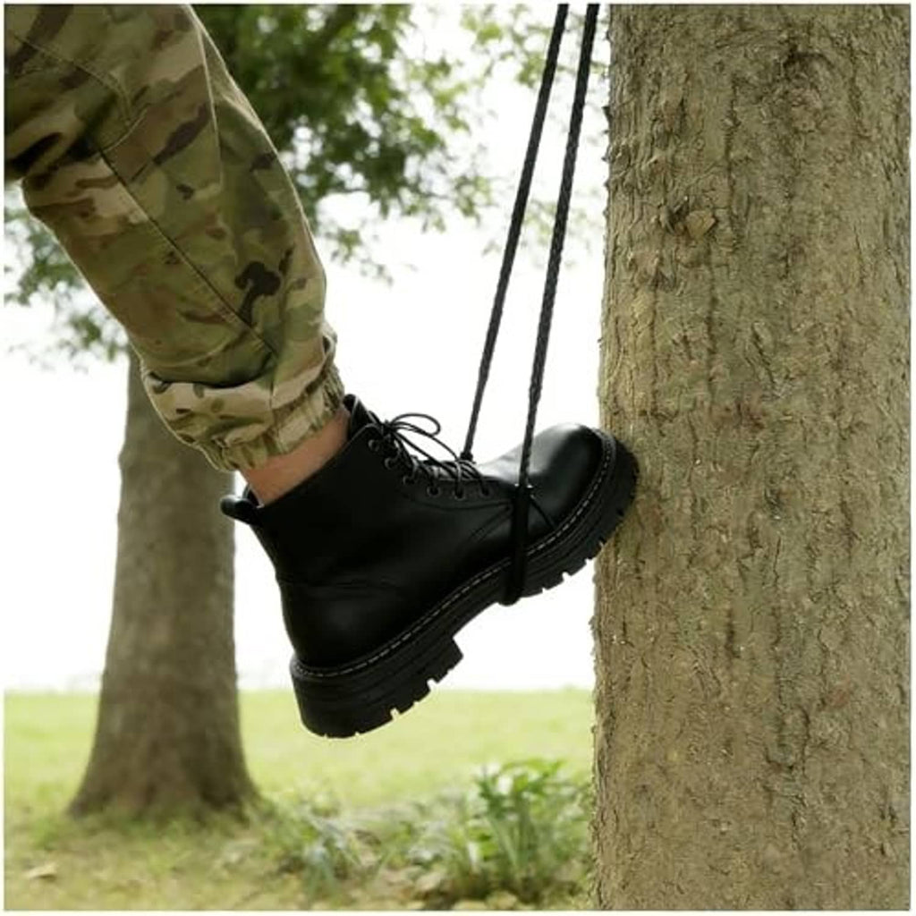 Black climbing strap ladder with foot hold loops, secured between tree trunks