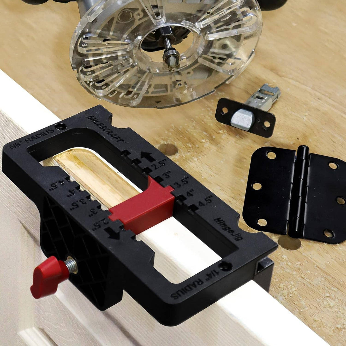 Door hinge jig with red lever, hinge bit, and two black hinge plates