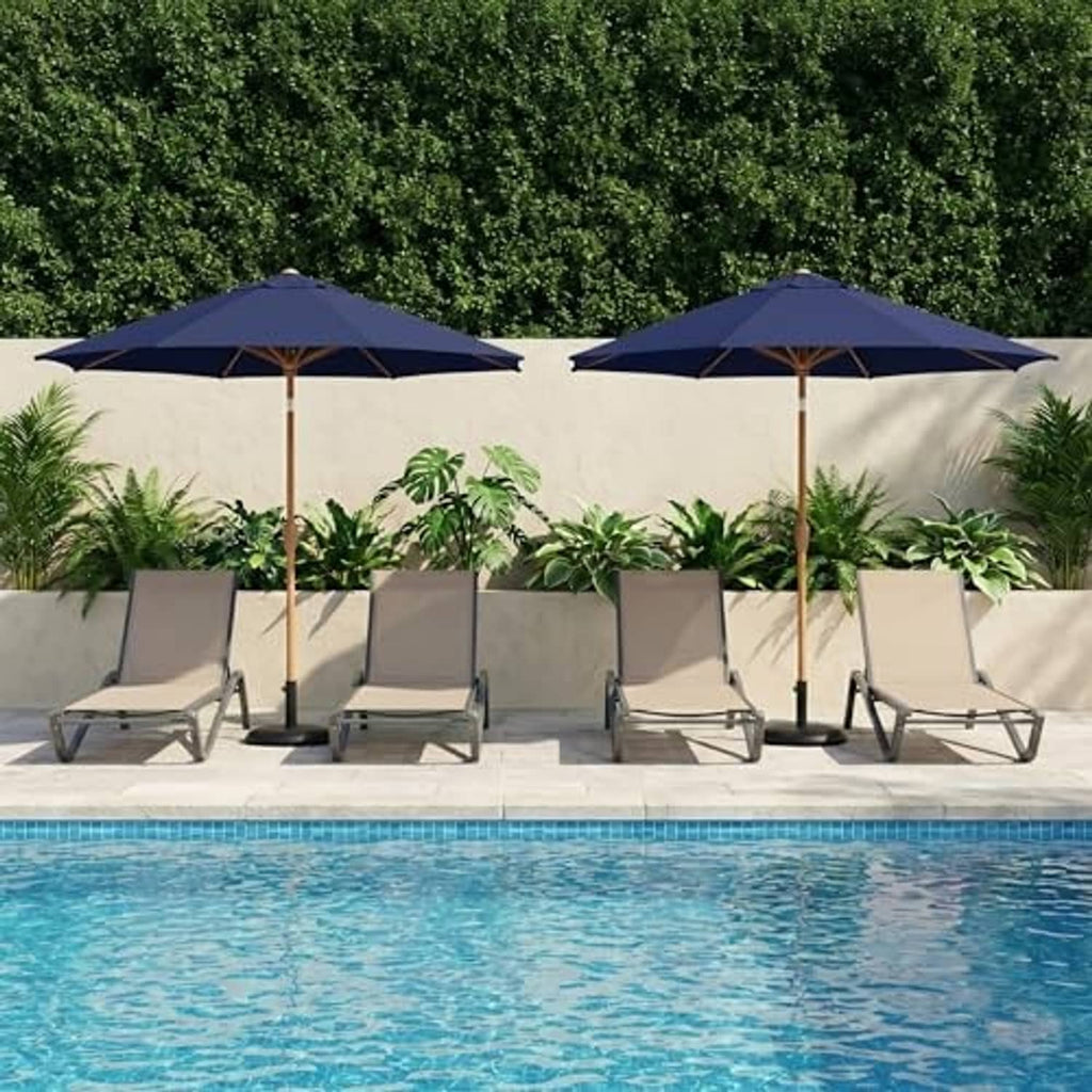 Two navy patio umbrellas over a poolside seating set with wooden poles