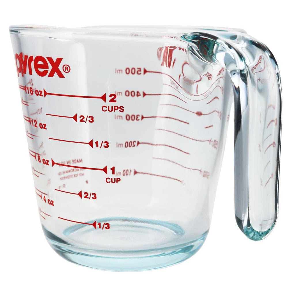 Glass measuring cup with red ounce and cup scale and curved spout handle