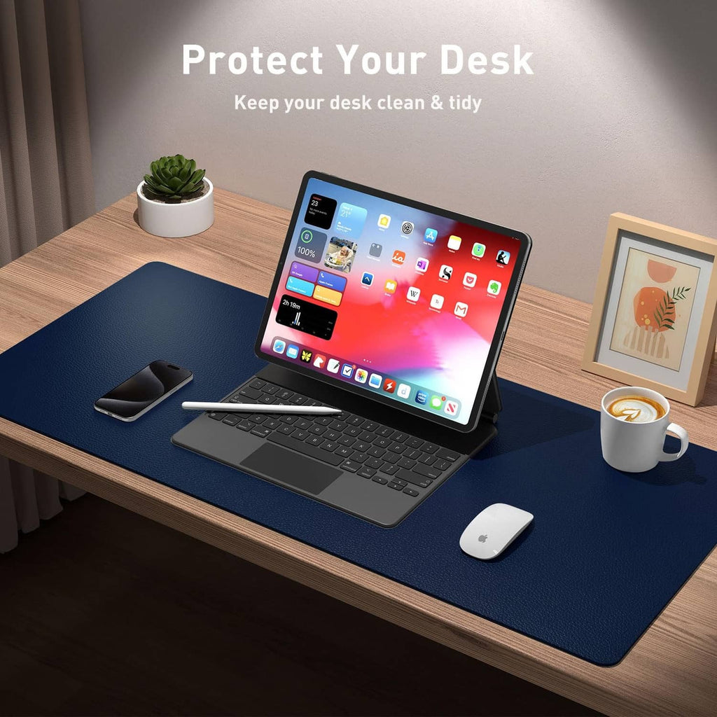 Dark blue desk pad protector under laptop and mouse on a home office desk