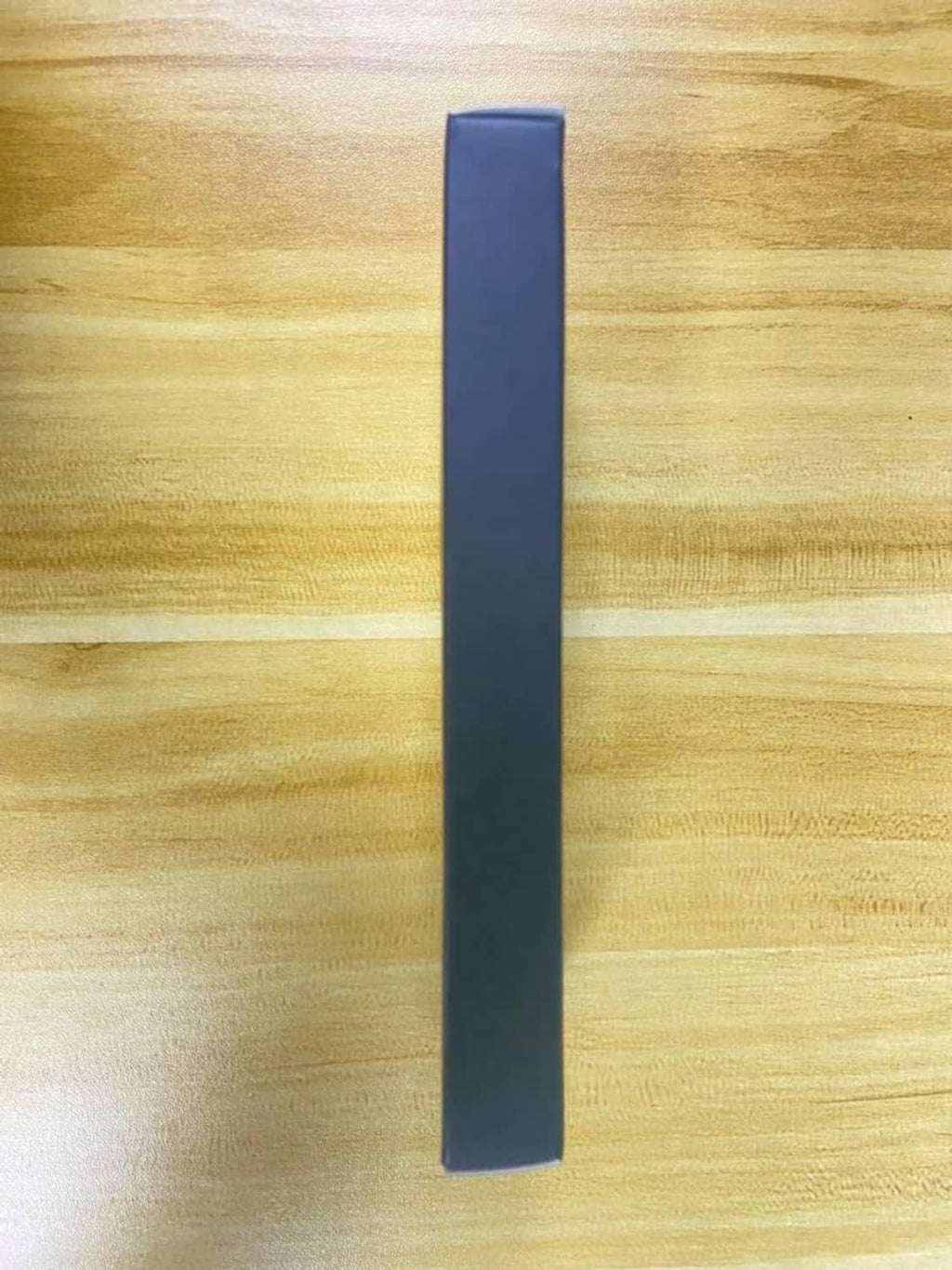 Blue retail box package upright on light wood surface