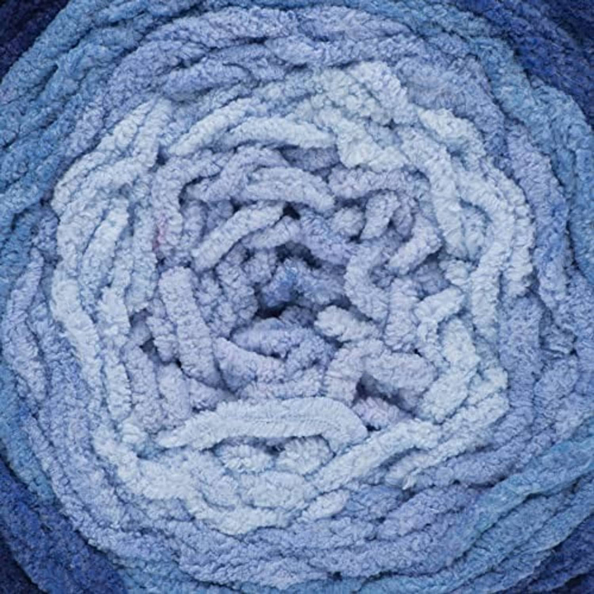 Light blue ombre yarn close-up with thick looped texture and spiral pattern