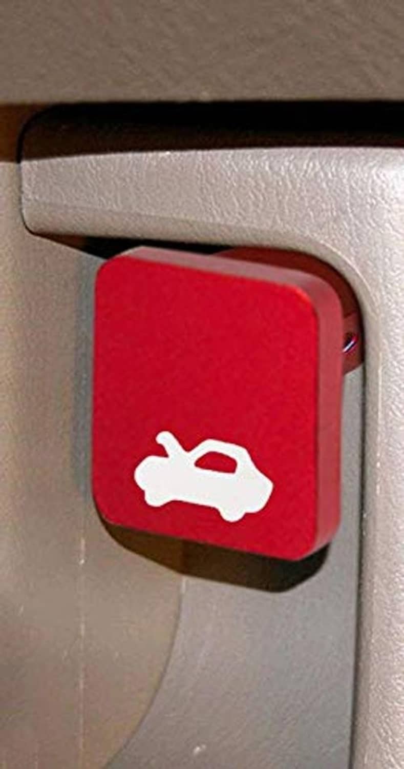 Red hood latch release handle button with wrench icon on dashboard trim.