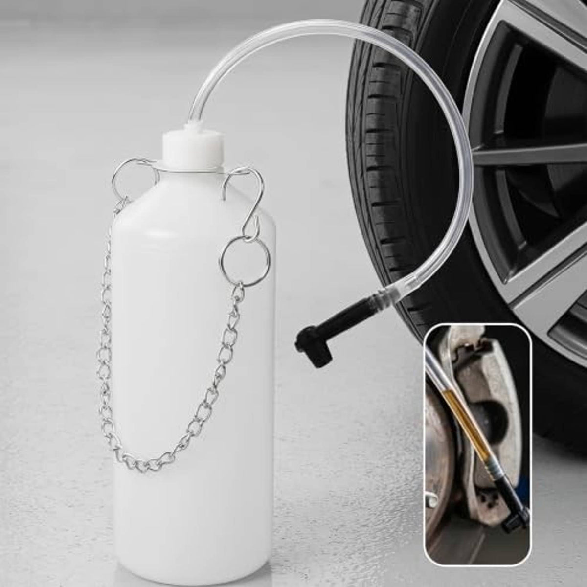 White brake bleeder bottle with chain hanger and clear hose connected to black pump