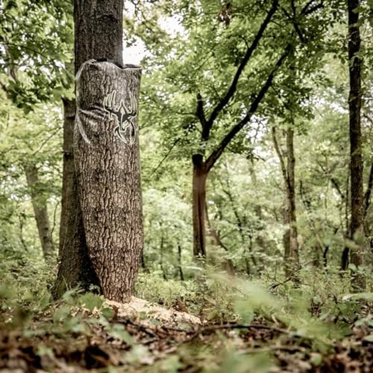 Tree-bark camo gravity feeder bag hanging on a tree