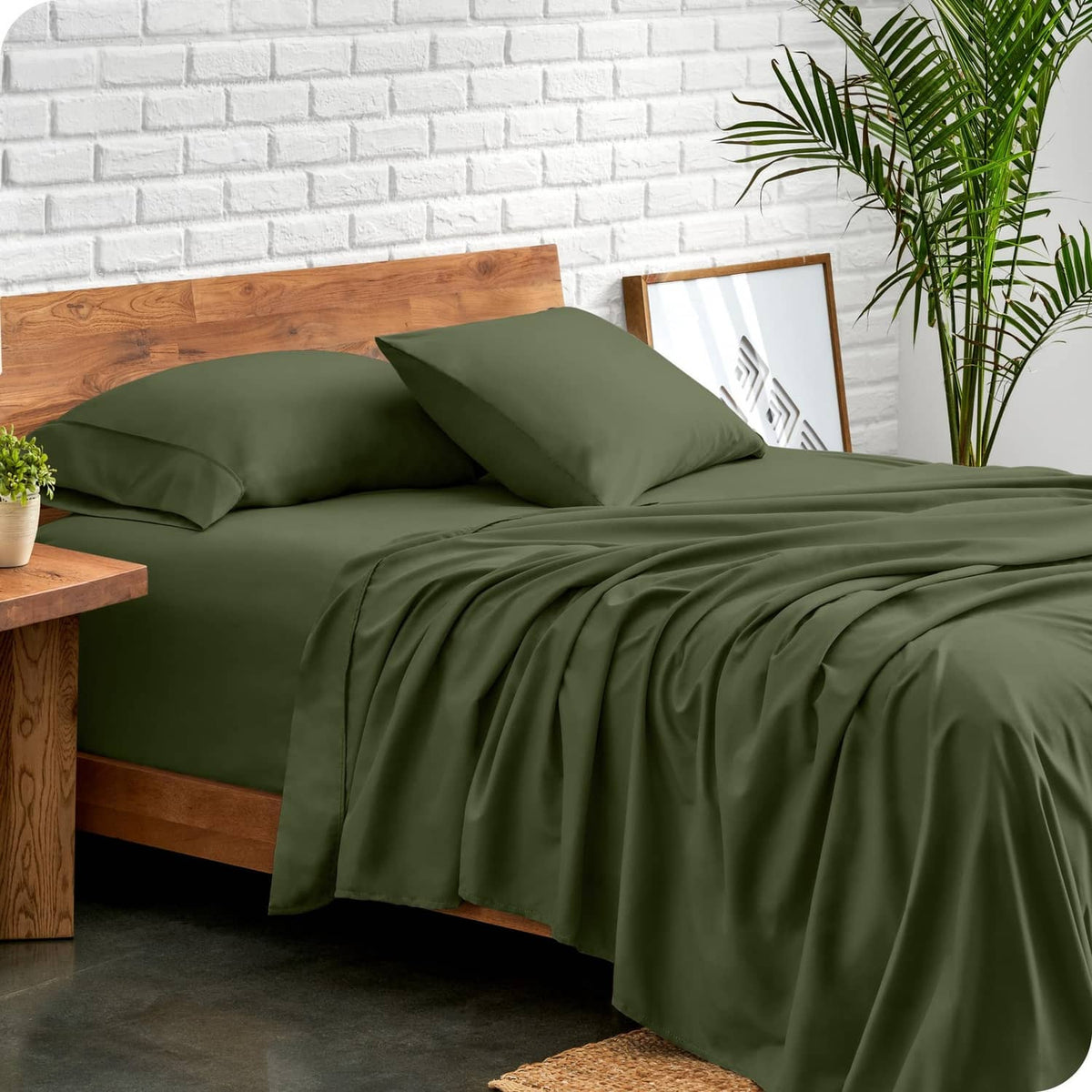 King bed sheet set in deep olive green with two pillowcases and neatly spread sheet