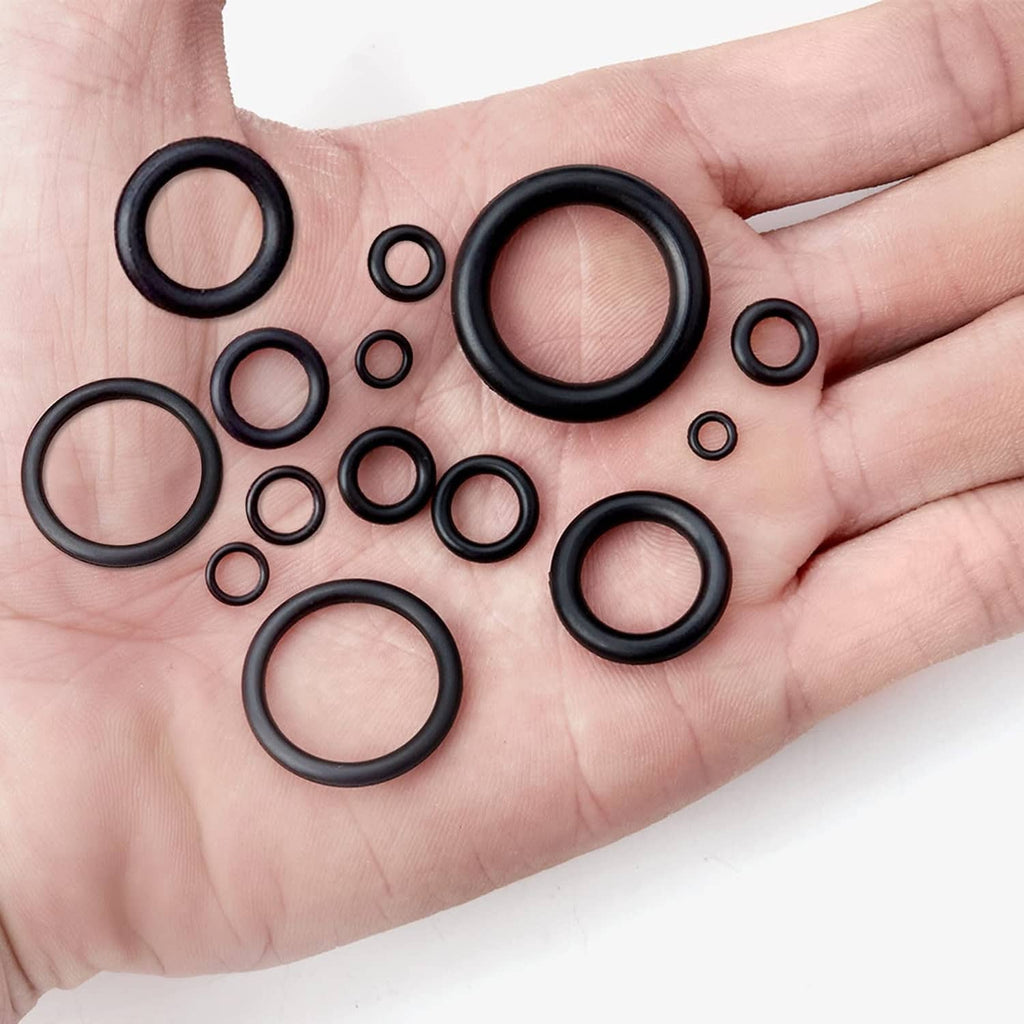 Assorted black O-rings held in hand, with several large and small rings