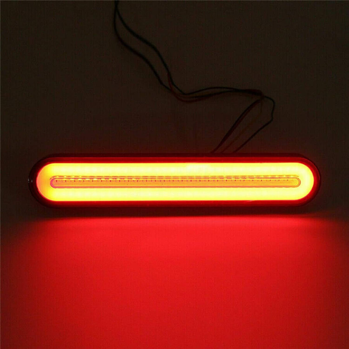 LED trailer tail light bar glowing amber-red in a dark setting