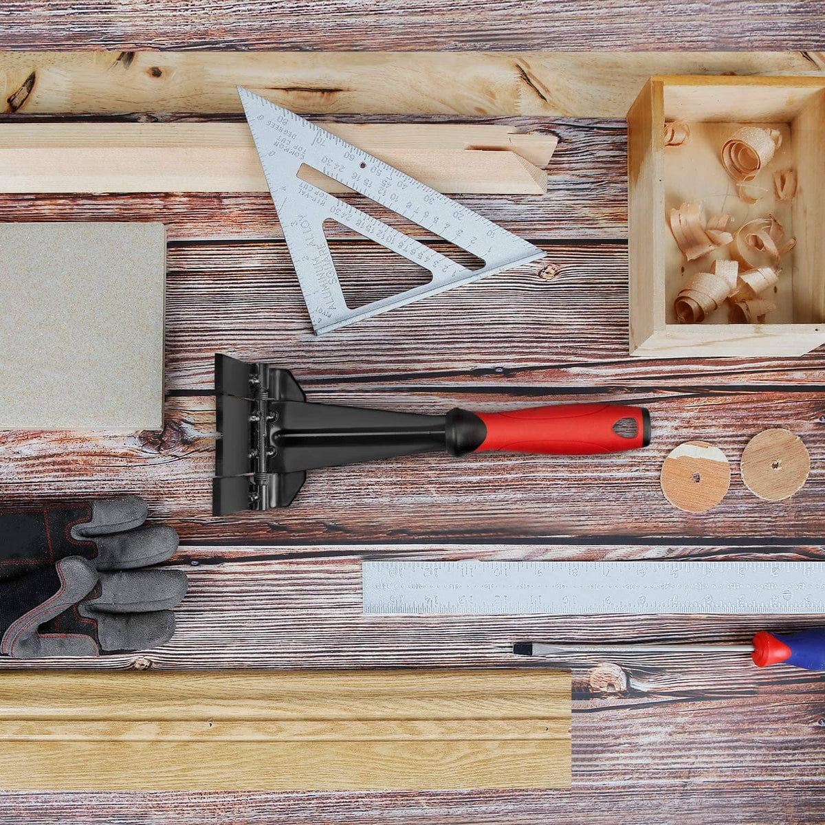 Trim puller multi-tool with red handle and black head on a wooden work surface