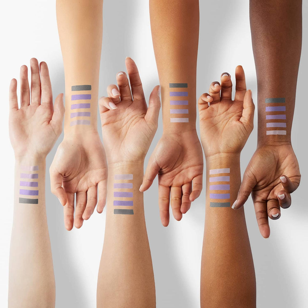 Purple matte eyeshadow swatches on forearms with striped pigment bands