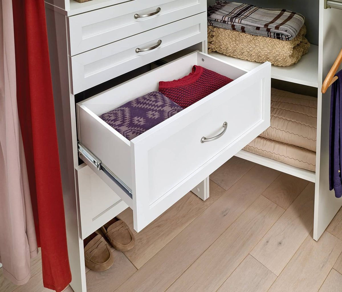 White shaker-style wood drawer with silver pull, open with folded fabric inside