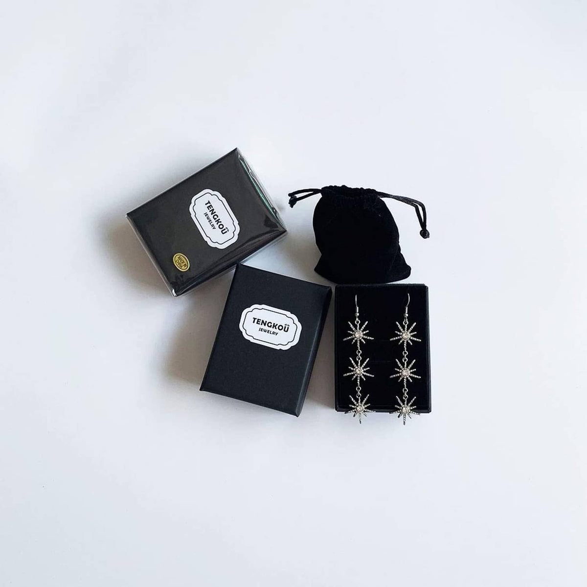 Accessory gift set with two black boxes and a black pouch featuring snowflake accents
