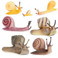 Set of 7 realistic mini snail figurines with detailed shells and antennae, assorted colors.