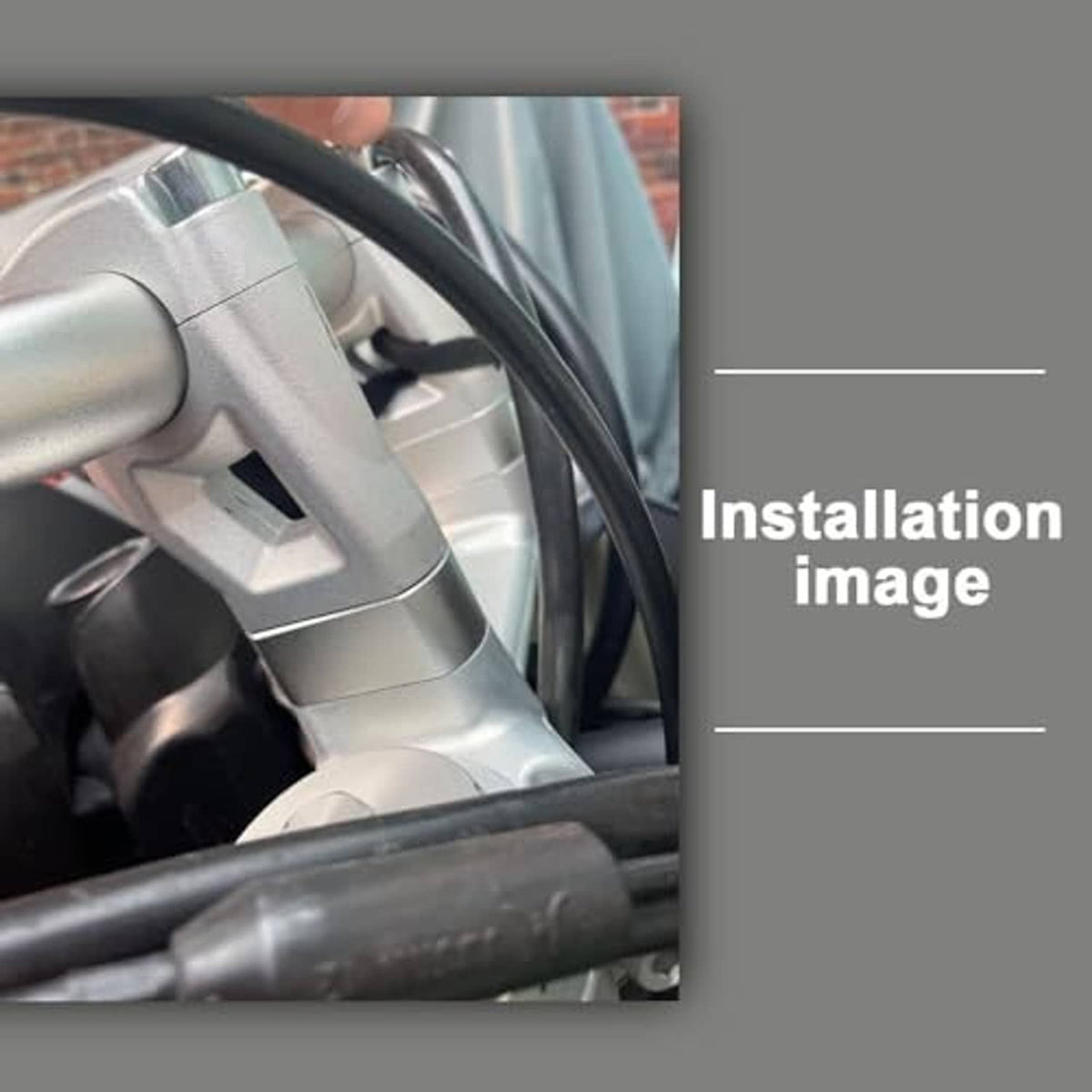 Installed silver motorcycle handlebar riser on handlebar clamp area