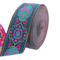Embroidered jacquard ribbon roll with dark base, teal and magenta floral medallions