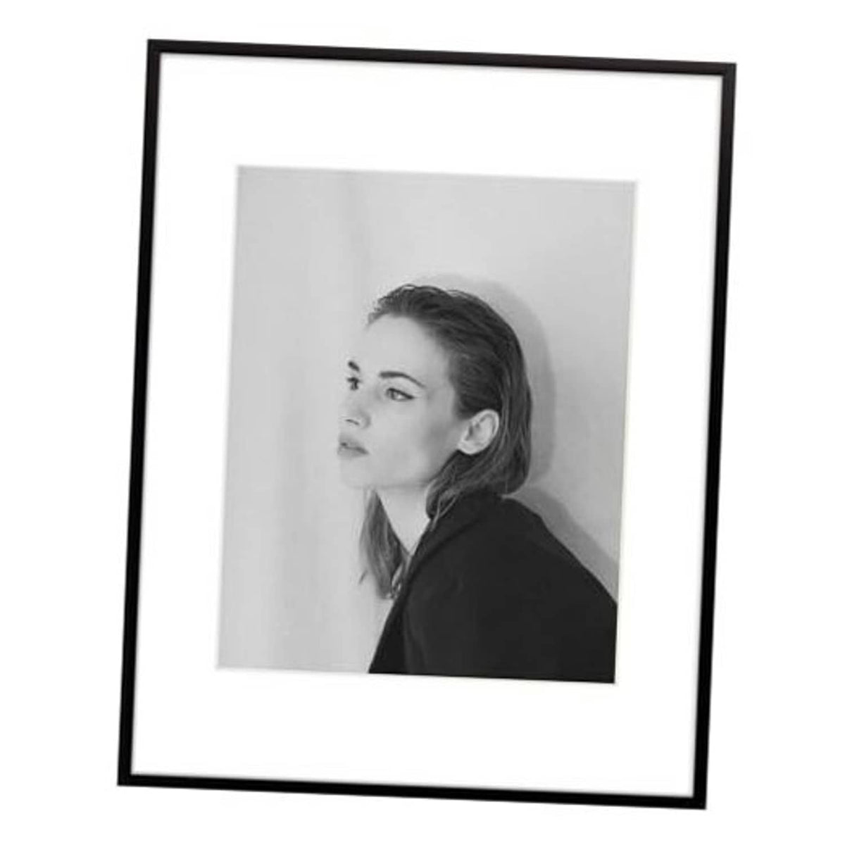 Black aluminum picture frame with white mat, displaying a grayscale portrait photo