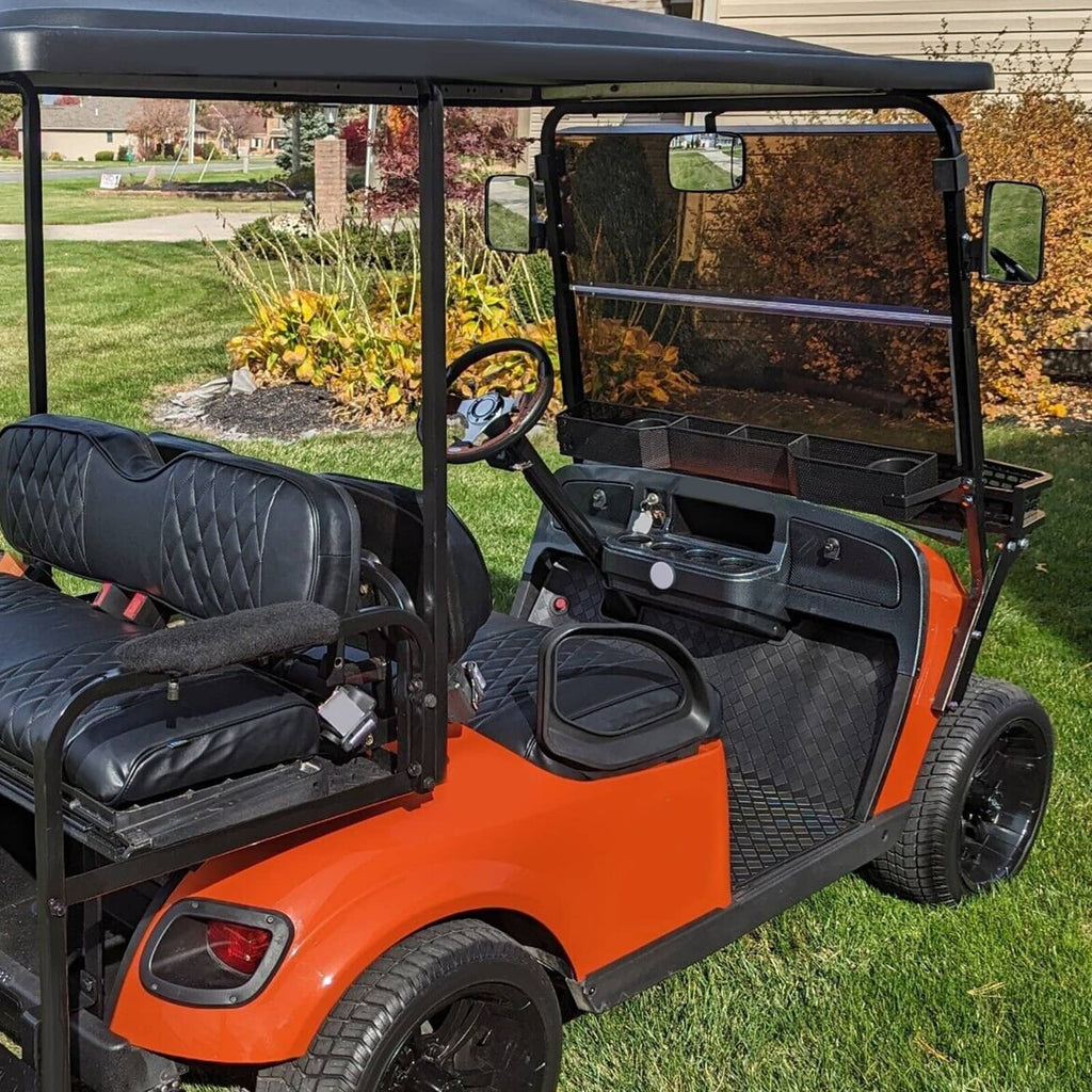 Installed tinted fold-down windshield on golf cart with black metal frame and smoky glass.