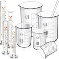 Set of clear glass measuring beakers and graduated cylinders with spouts and handles