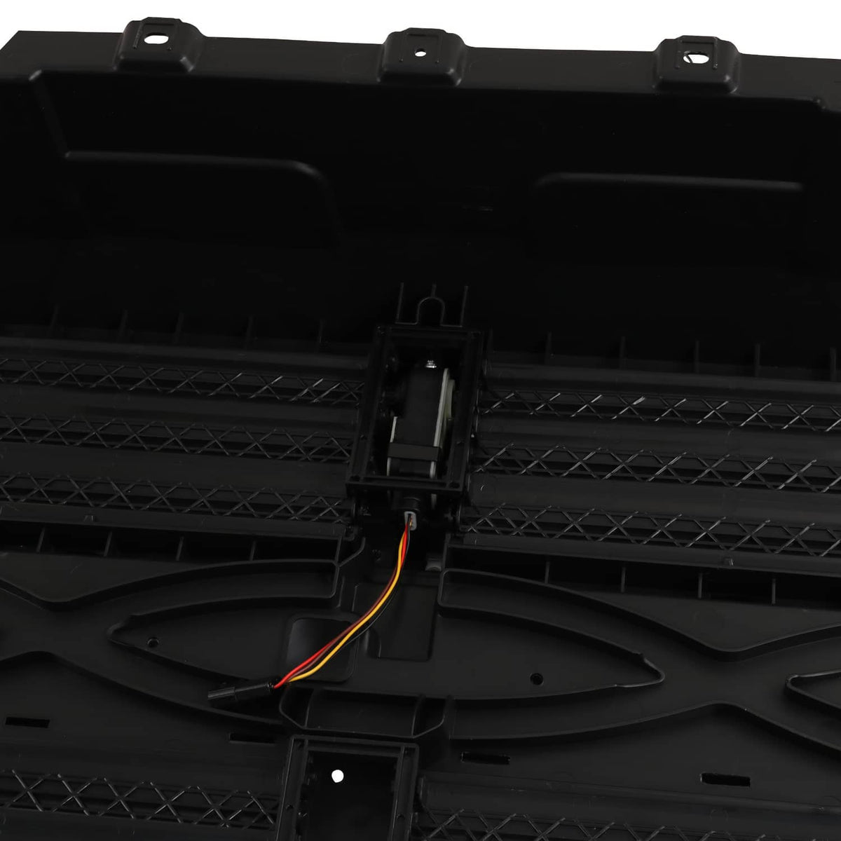 Black grille shutter panel with central actuator housing and orange wire leads