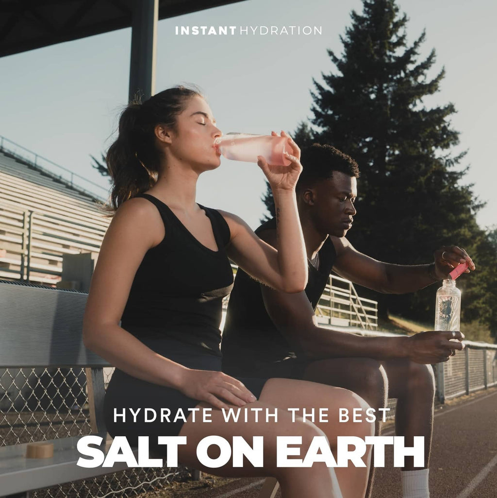 Lychee electrolyte drink mix bottle held while hydrating outdoors