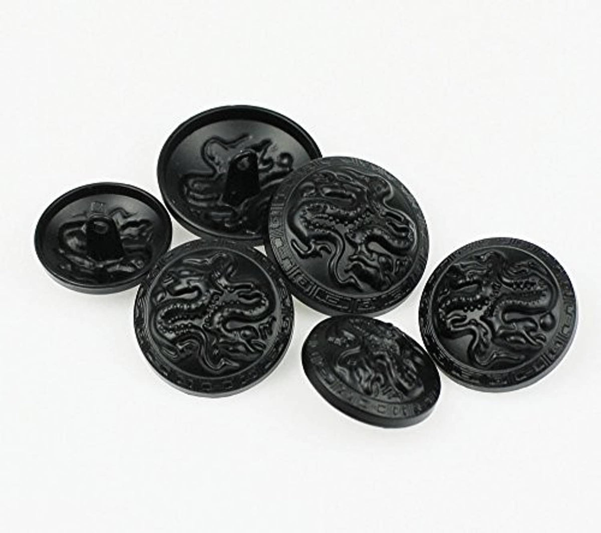 Round metal buttons with embossed dragon relief, dark finish, angled view of set