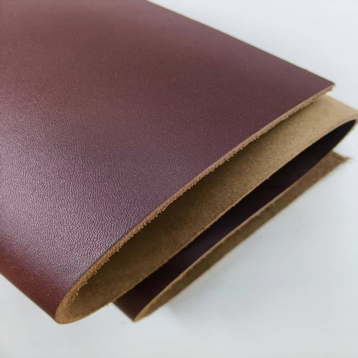 Brown leather sheet edge view, tan underside visible along the cut seam