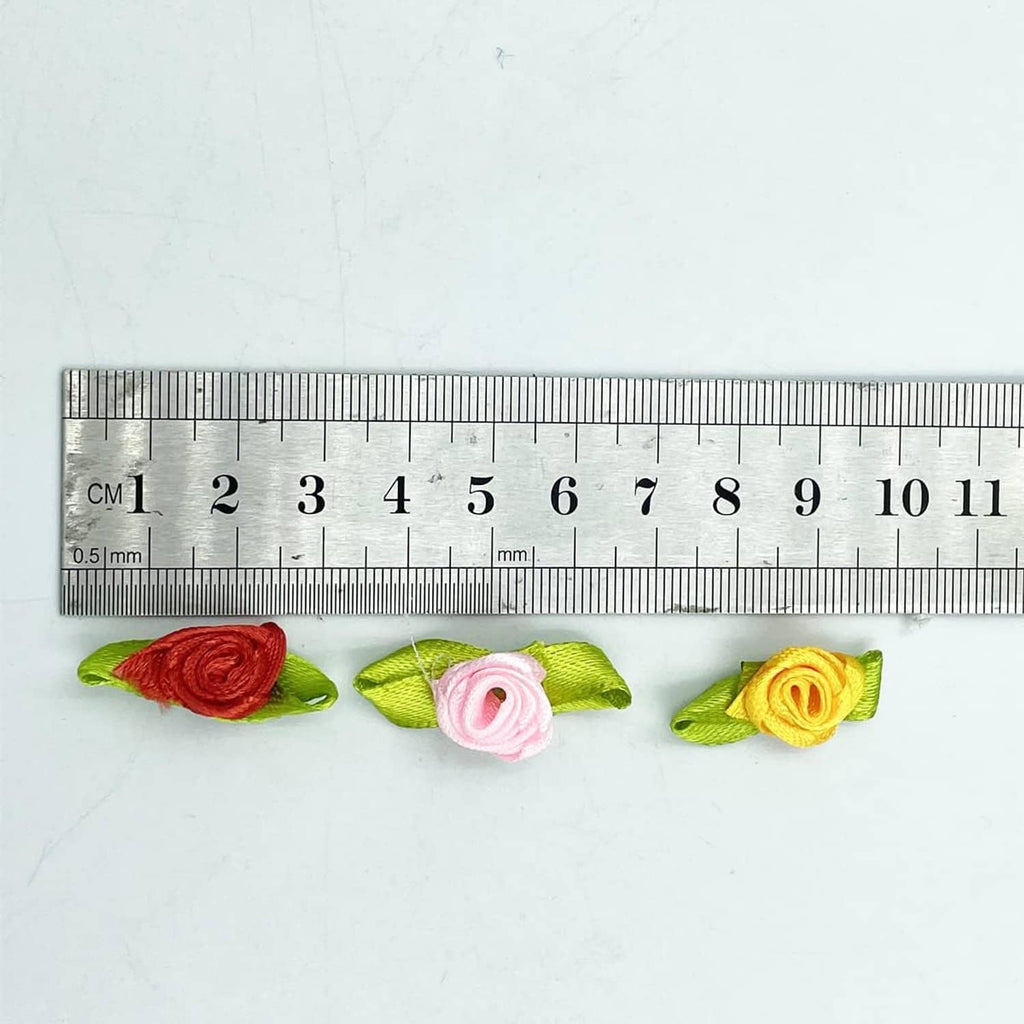 Mini ribbon rose flower with green leaves shown next to a ruler for size