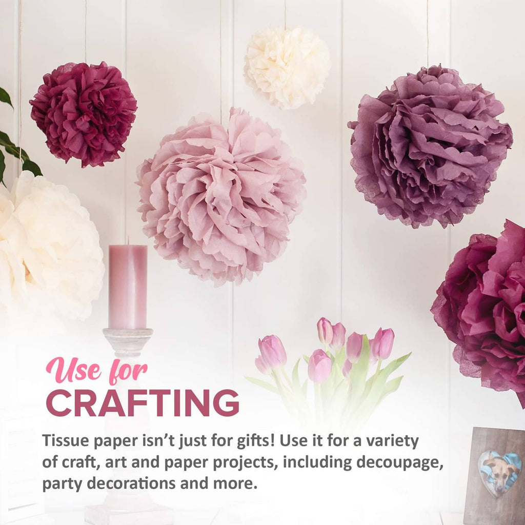 Purple, pink, and white tissue paper pom-poms hanging for crafting and party decor