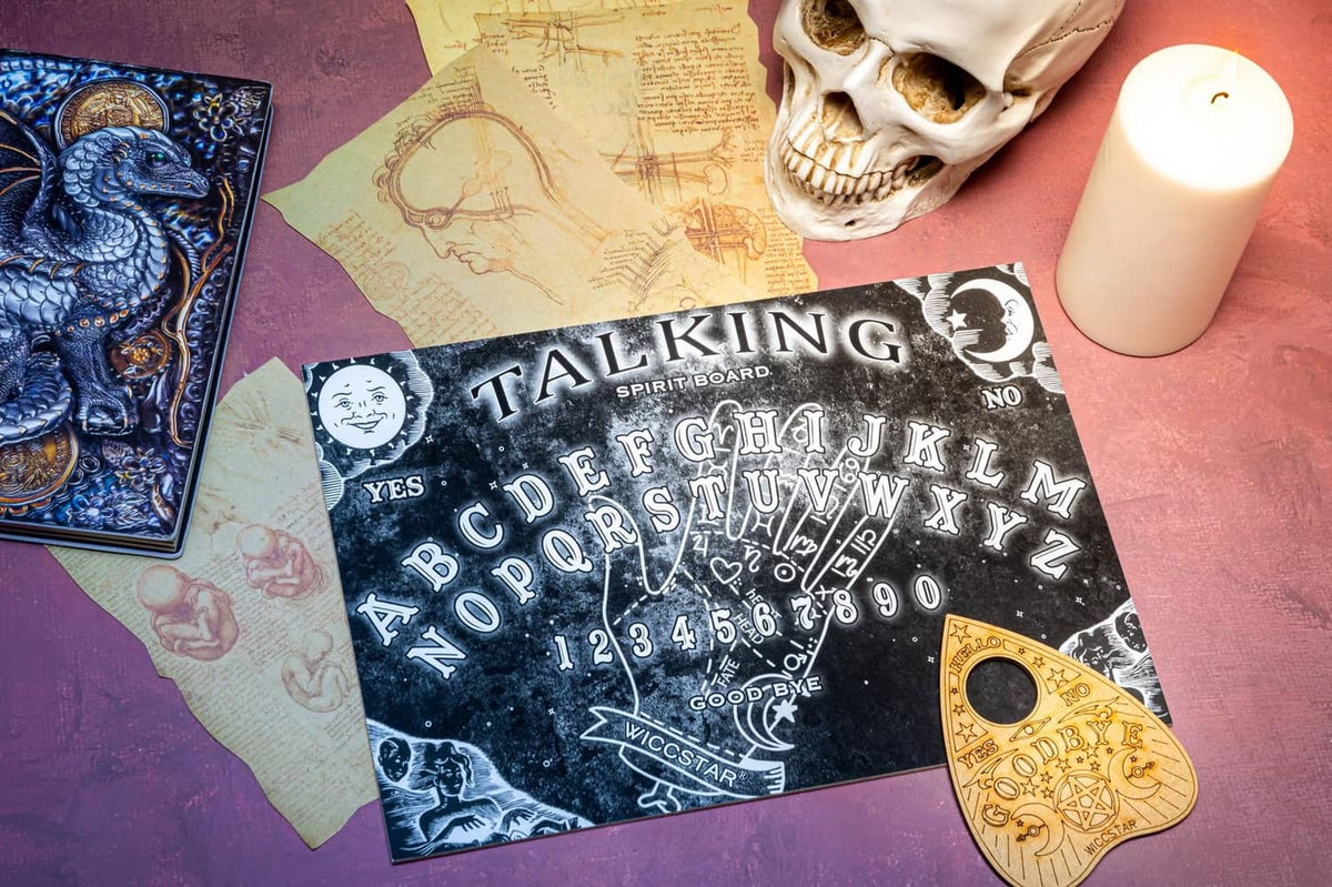Talking spirit board game with black board, alphabet chart, and gold planchette