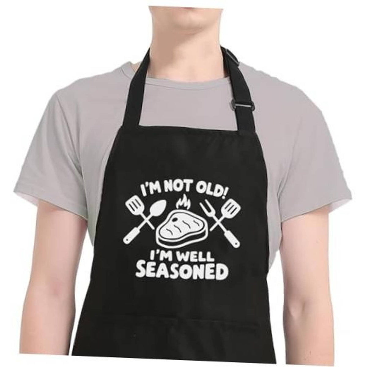 Black cooking apron with adjustable neck strap and humorous "well seasoned" design