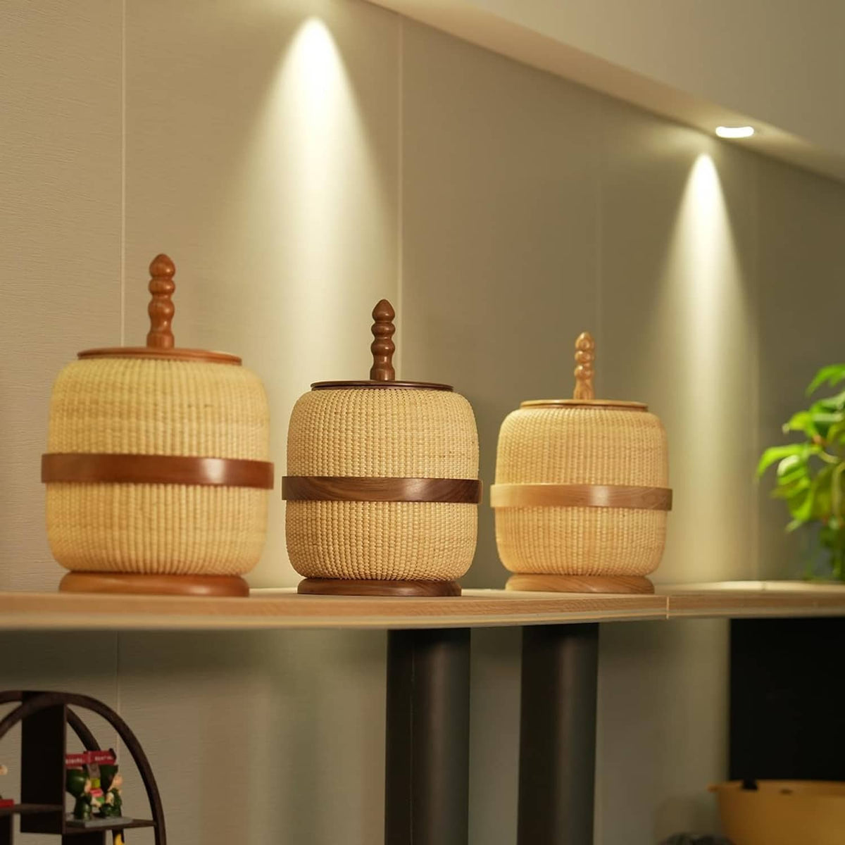Set of woven rattan storage baskets with wooden lids and finials, yellow beige
