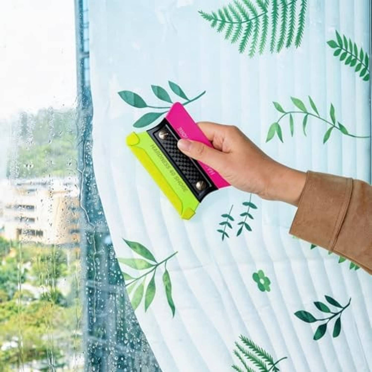 Neon green pre-cut squeegee felt buffer being applied to window surface