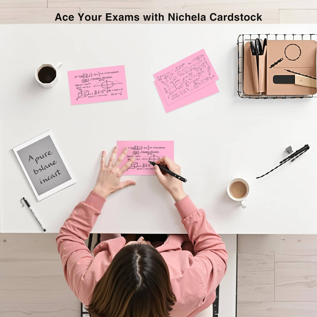 Pink blank index cards on desk with pens and coffee