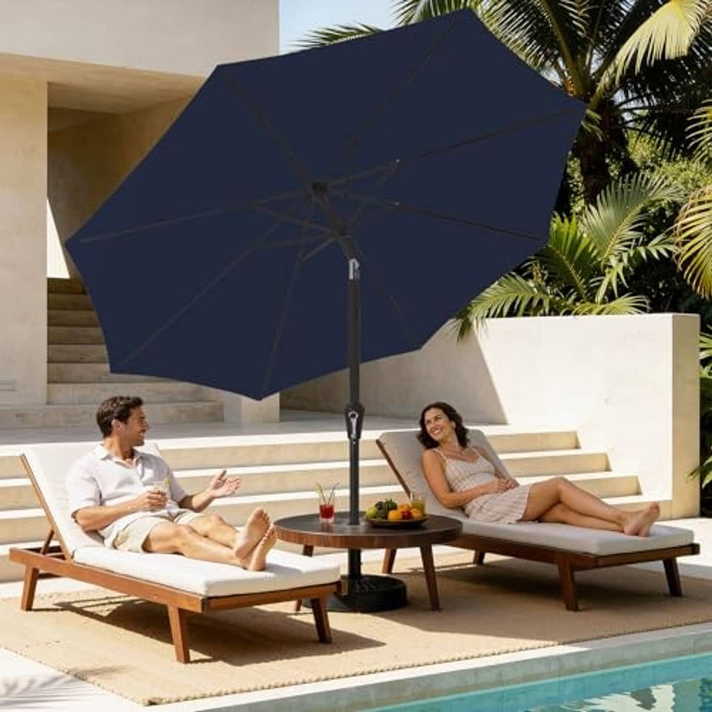 Navy patio umbrella open canopy above outdoor lounge chairs, straight pole