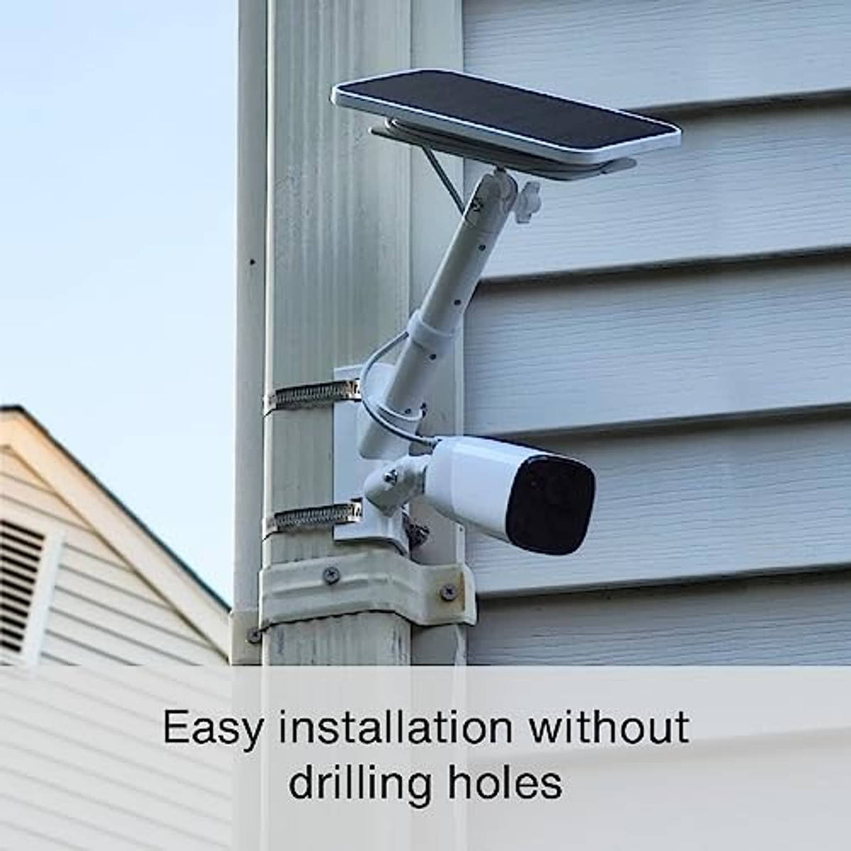 White camera mount with solar panel mount attached to an exterior wall pole