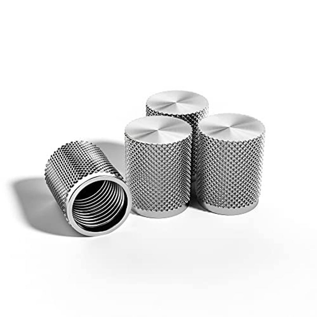 Four stainless steel tire valve caps, textured metal body, one cap with open threads