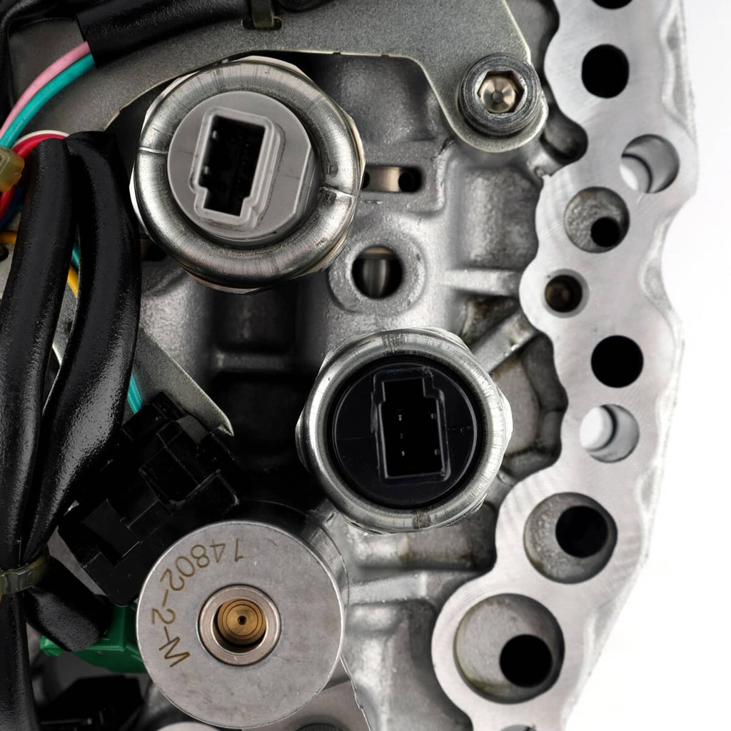 Close-up of transmission valve body connector ports on silver-gray metal with wiring nearby.